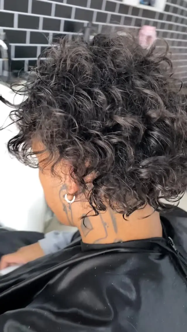 Cacheado finalizado, cliente de costas com tatuagem no pescoço